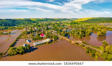 Flooded villages in western Ukraine. Flood on the Dniester River. View from flying drone of Nyzhniv village after few days of huge rain. Disaster concept background. Flooded fields and farm houses.