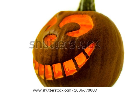 Glowing Halloween Pumpkin isolated on white background. Wide smiling Jack O Lantern halloween pumpkin with candle light inside. The Cheshire Cat shape carved pumpkin.