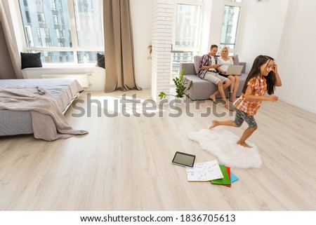 Curious little child girl having fun using digital tablet on floor, happy preschool smart kid playing with computer looking at screen watching cartoons online at home