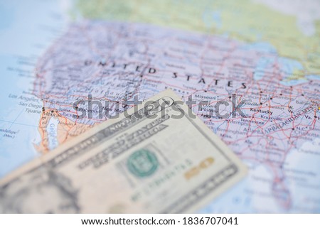 Picture of The United States of America on a blurry Map and with a Twenty-Dollar banknote on Top