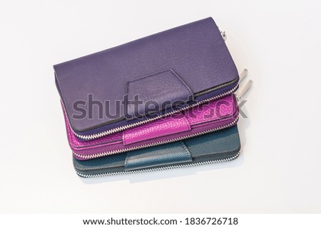 three multicolored purses on a white table