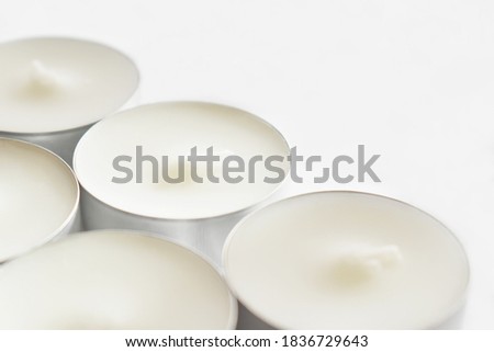 White tealight candles on white background. 
