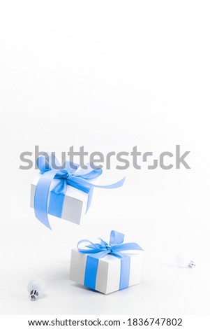 Christmas sale. White gift box with blue ribbon, New Year balls in xmas composition on white background for greeting card. Christmas, winter, new year concept.
