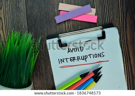 Avoid Interruptions write on a paperwork isolated on Wooden Table. Motivation or Insipiration Concept Royalty-Free Stock Photo #1836748573