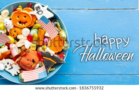 Halloween Jack o Lantern candy bowl with candy and halloween cookies Trick or Treat on patriotic american background, usa flag