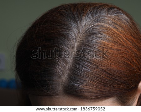 head of a woman with gray hair dyed with henna
