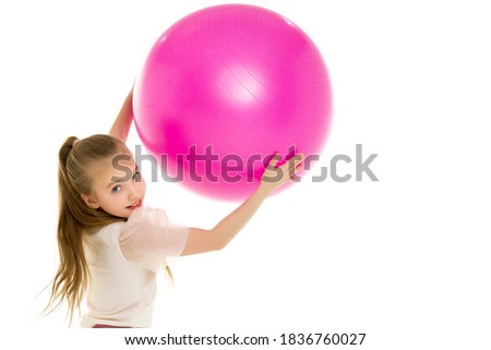 Little girl plays with a big ball for fitness