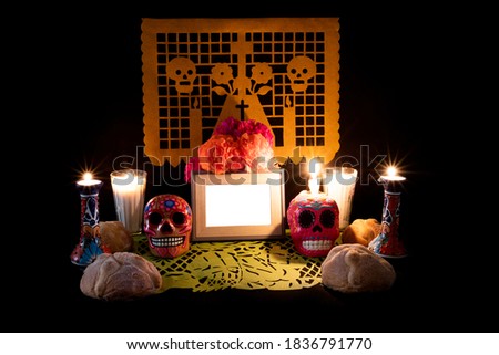Day of the Dead offering from central Mexico with papel picado, veladoras, photography, flowers and bread of the dead