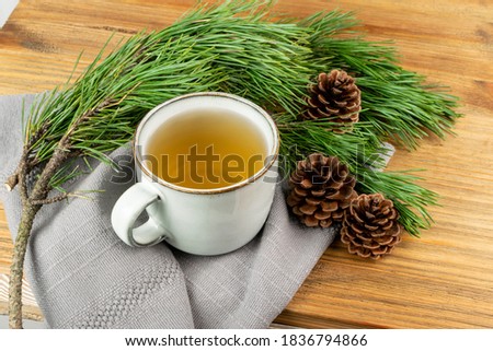 Pine needles tea in old cup. Healthy winter beverage in camping, pine tree needles tea in vintage mug. Medicine scurvy, source of vitamin C and carotene Royalty-Free Stock Photo #1836794866
