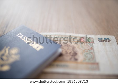 Picture of a blurry United States of America Passport with a Fifty Burmese Kyats Bill partially inside