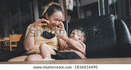 Asian beautiful Mother and child happily hugged and kissed each other's cheeks. Asian family mom and child are hugging and fragrant, cheeks together, Touch of love and family relationship.