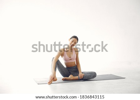 Beautiful girl in yoga studio. A woman doing a yoga. Lady in a pink top.