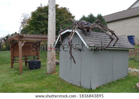 A giant spider on top of a shed 