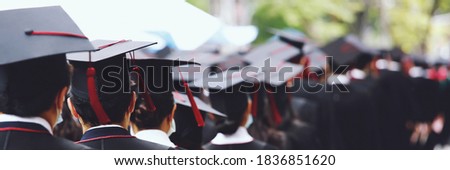 Group of Graduates during commencement stand in row. Concept education congratulation in University. Graduation Ceremony. copy space banner.