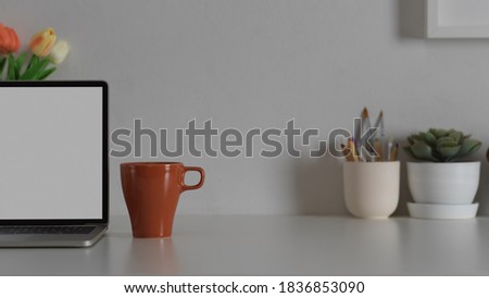 Close up view of workspace with laptop, mug, decorations and copy space on white table, clipping path
