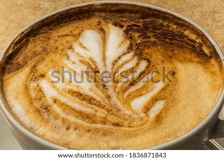 Cup of coffee cappuccino with a picture on the table