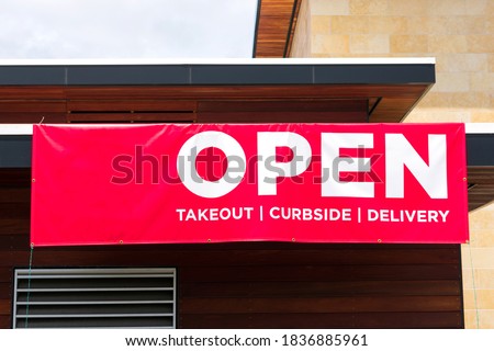 Open for takeout, curbside and delivery outdoor advertisement banner on business building exterior