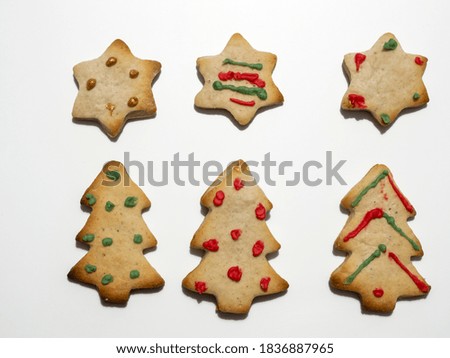 Homemade Christmas gingerbread cookies isolated on white background. Pine and star shaped cookies. Decorated Christmas cookies