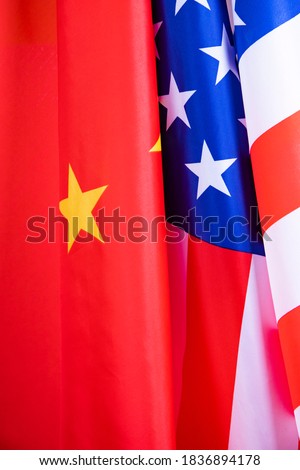 Flag of the United States with China on a waving cotton texture background. Concept of political relationships and conflicts.