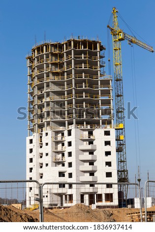 construction of a new monolithic building with a large number of apartments, a building on the edge of the city in a new urban area, construction of new comfortable housing made of reinforced concrete