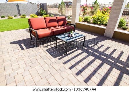 Rear Patio With Pavers, Coffee Table And Couch With Cushions Royalty-Free Stock Photo #1836940744