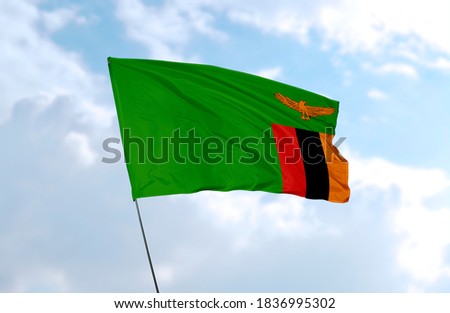 Flag of Zambia in front of blue sky