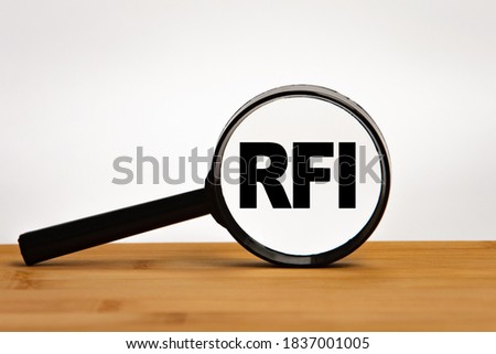 Focused on business concept. Magnifier glass with word RFI Request for information on wooden table. Business concept. Search idea