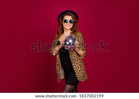 Portrait of her she nice-looking attractive fashionable pretty cheerful wavy-haired girl holding in hand silver round mirror ball having fun isolated on red maroon burgundy marsala color background