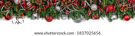 Christmas border frame design copmosition of fir tree branch and red silver decorations balls baubles ribbon pine cones isolated on white background