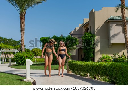 nice group of beautiful young women, two teenage girls smile and walk together on the beach in vacation. happiness and nice body for enjoyed people live an alternative lifestyle as vacation forever 