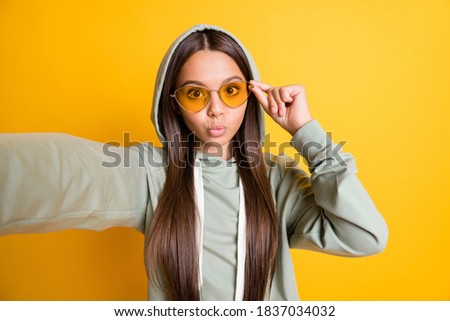 Portrait of brunette hair blogger touch glasses trendy isolated on yellow color background