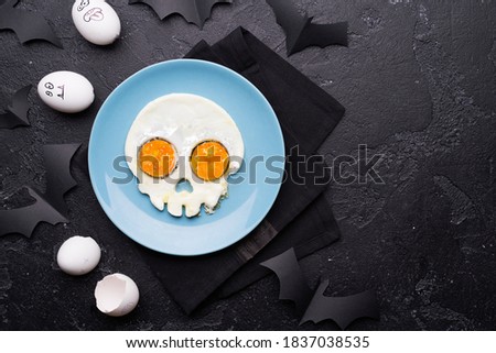 Fried eggs in the shape of a skull. Halloween breakfast. Top view.