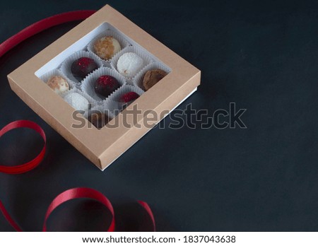 Homemade chocolate truffle candies on a dark background. in a gift box. Chocolate round candies for the holiday