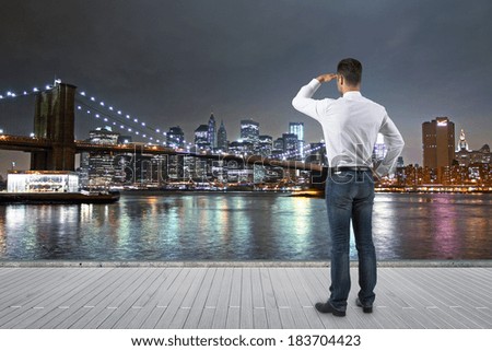businessman standing on the pier and looking at brooklyn bridge