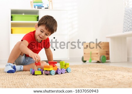 Cute little boy playing with colorful toys on floor at home, space for text Royalty-Free Stock Photo #1837050943