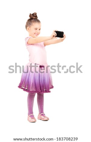 Full length portrait of little ballerina taking a selfie isolated on white background