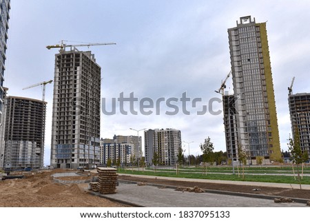 Tower cranes in action at construction site. Construction process of the new modern residential buildings. Road work and streets repair in city. Preparing to pour of concrete into formwork.