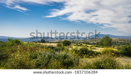 Panoramic view in late spring of the rural area of ​​the town of Braojos in Madrid with blue sky and white clouds.