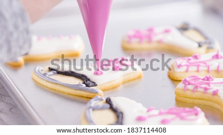 Icing figure skate shaped sugar cookies with royal icing.