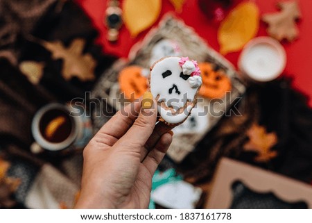 Halloween concept with cookies in hands on colorful background