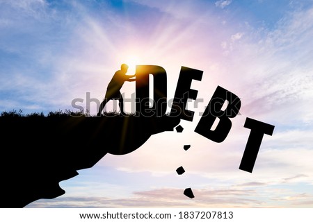 Eliminate or get rid of debt concept , Silhouette man pushed off debt wording a cliff with blue cloud sky and sunlight. Royalty-Free Stock Photo #1837207813