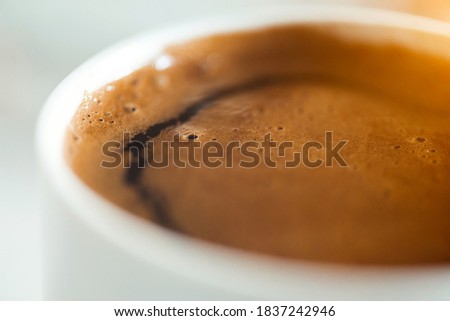 Cup of black coffee close-up shot of foam
