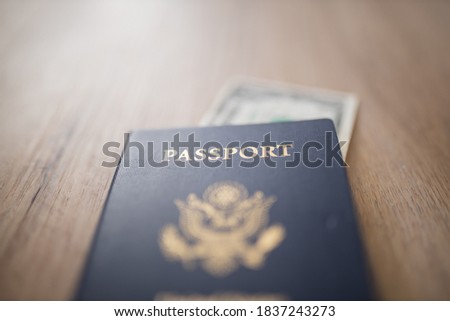 Picture of a blurry One-Dollar Bill Partially inside a United States of America Passport