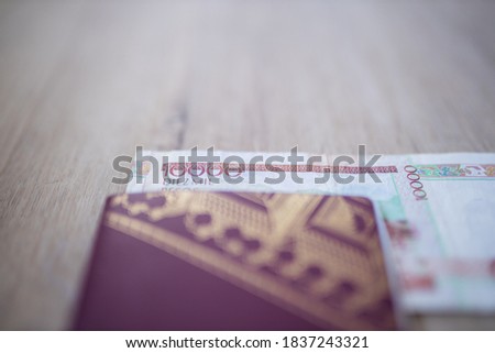 Picture of a Blurry Swedish Passport with half a 10.000 Colombian Pesos Bill Inside