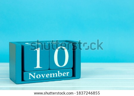 wooden calendar with the date of November 10 on a blue wooden background, International Day of Embroiderers; World Youth Day; World Science Day; International day of accounting