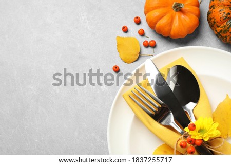 Seasonal table setting with pumpkins on light grey background, flat lay. Thanksgiving Day