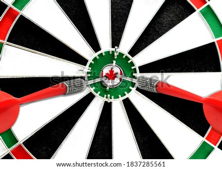 Close-up of a dart board with an imprinted flag of Canada in the center. The concept of achieving goals.