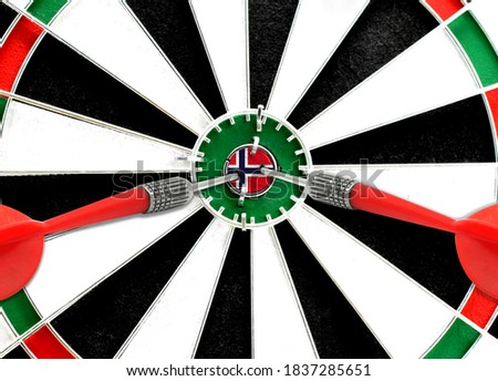 Close-up of a dart board with an imprinted flag of Norway in the center. The concept of achieving goals.
