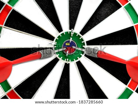 Close-up of a dart board with an imprinted flag of Liechtenstein in the center. The concept of achieving goals.