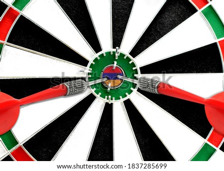 Close-up of a dart board with an imprinted flag of Armenia in the center. The concept of achieving goals.